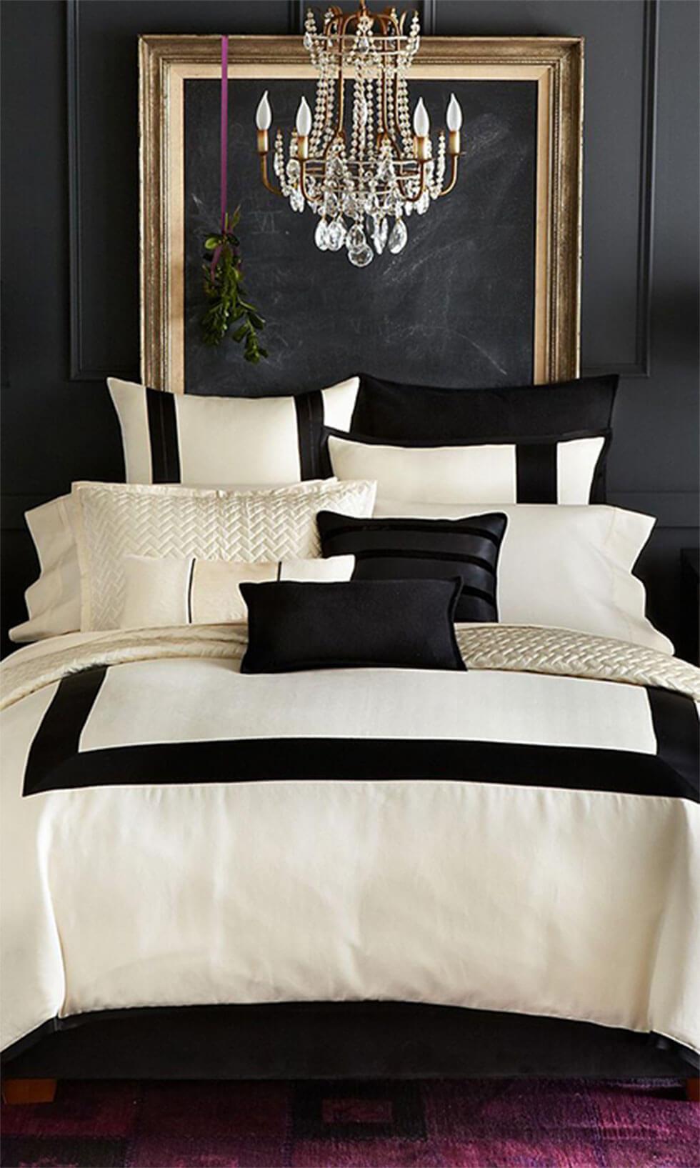 Sophisticated and luxurious black and white bedroom with chandelier, feature wall, and purple carpet