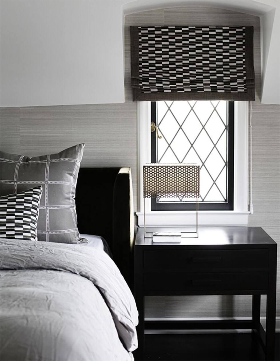 Black and white bedroom with patterned blinds and cushions