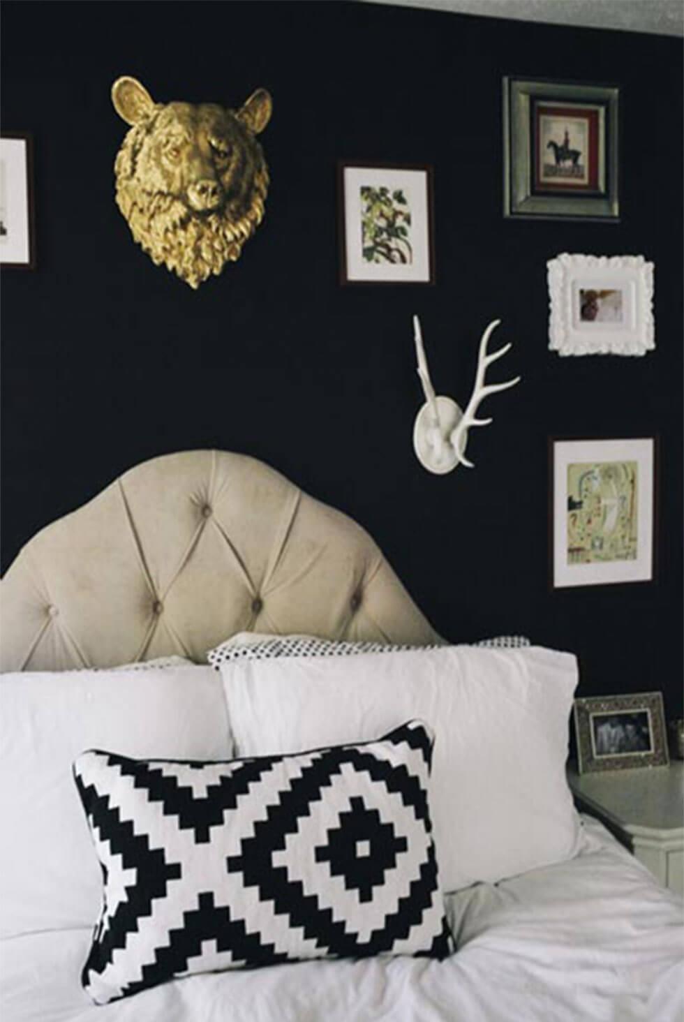 Quirky black bedroom with art and wall decor, printed cushion and upholstered headboard