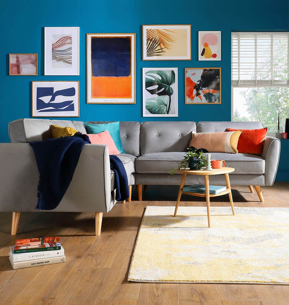 Scandi corner sofa in tropical blue dining room with gallery wall
