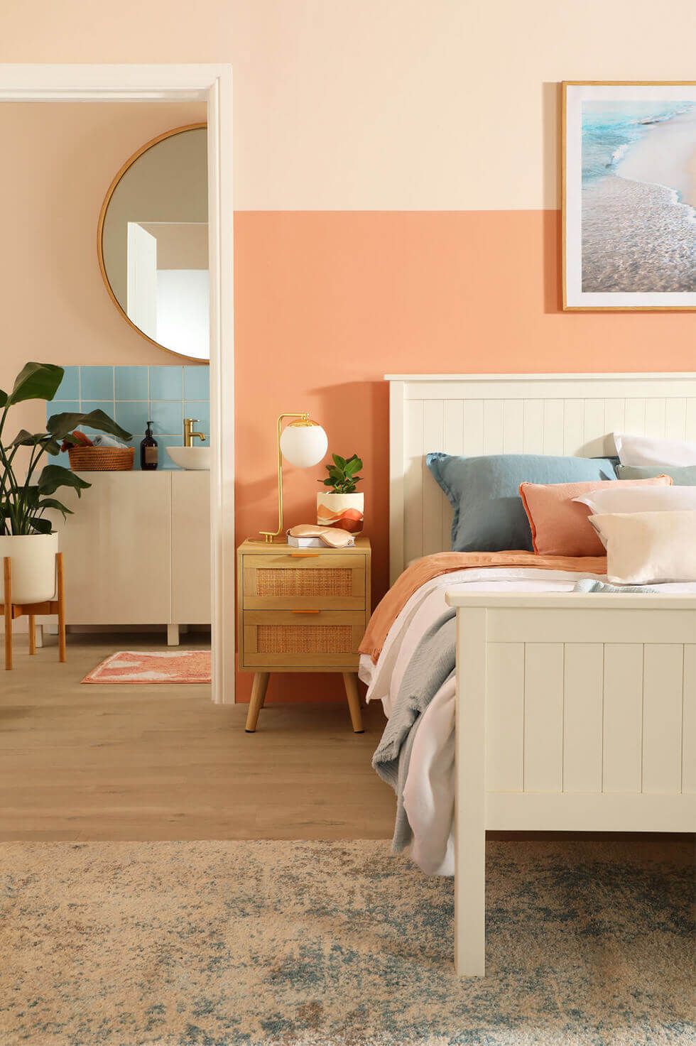 Bedroom with two-tone peach walls, wooden bed and bedside table