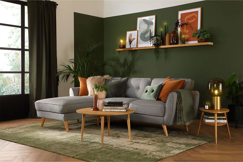 Cosy neutral living room with grey fabric corner sofa, round mirror and cushions