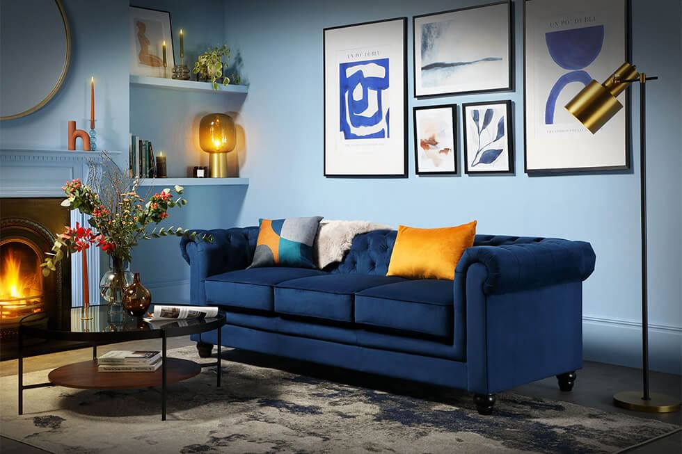 Blue velvet sofa with cushions and throws in blue living room