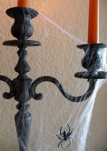 Fake cobwebs and spider on a black candelabra. 