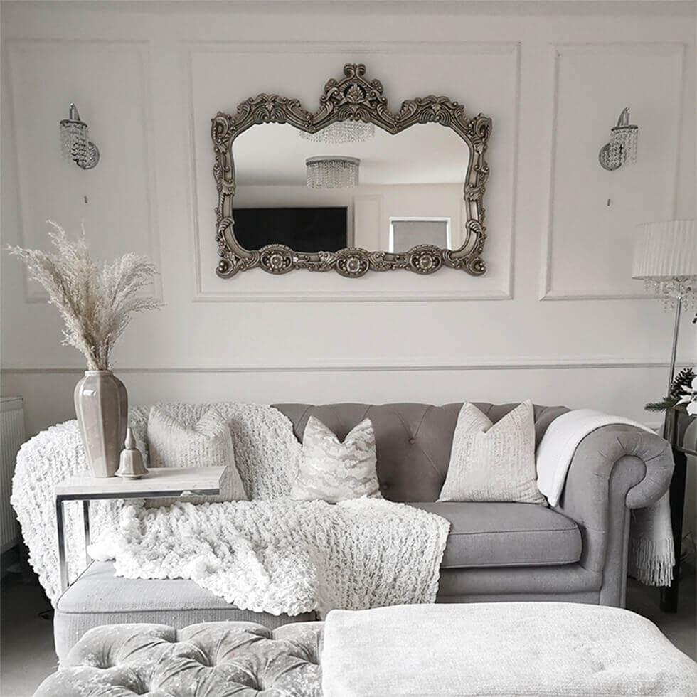 Neutral grey and white living room with ornate mirror, grey sofa and pampas grass in a vase