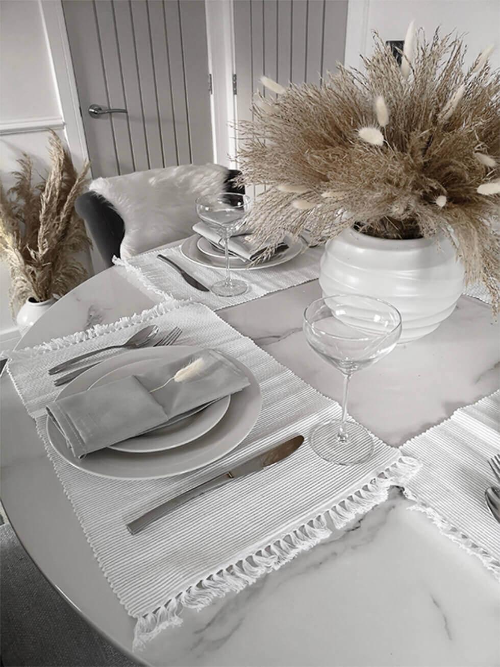 Close up of a dining table setting with a pampas grass centrepiece