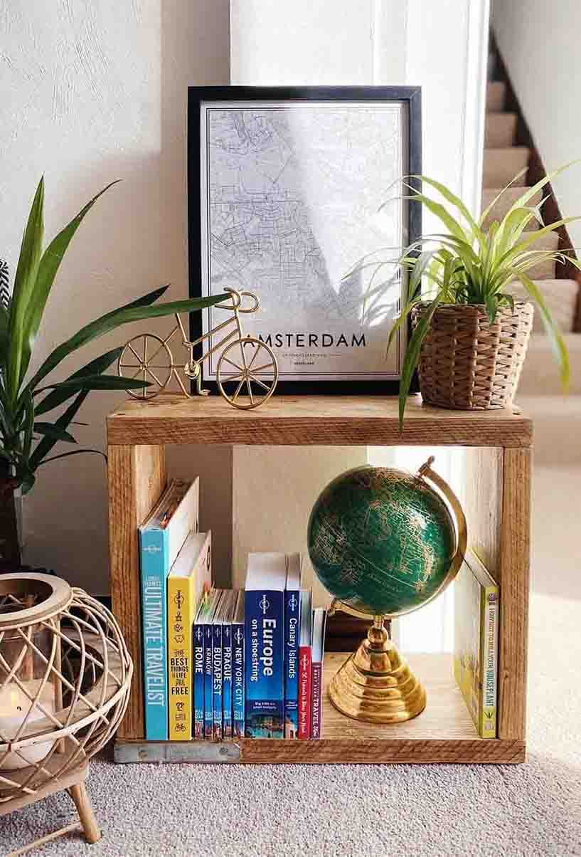 DIY side table with travel books, a globe and plants