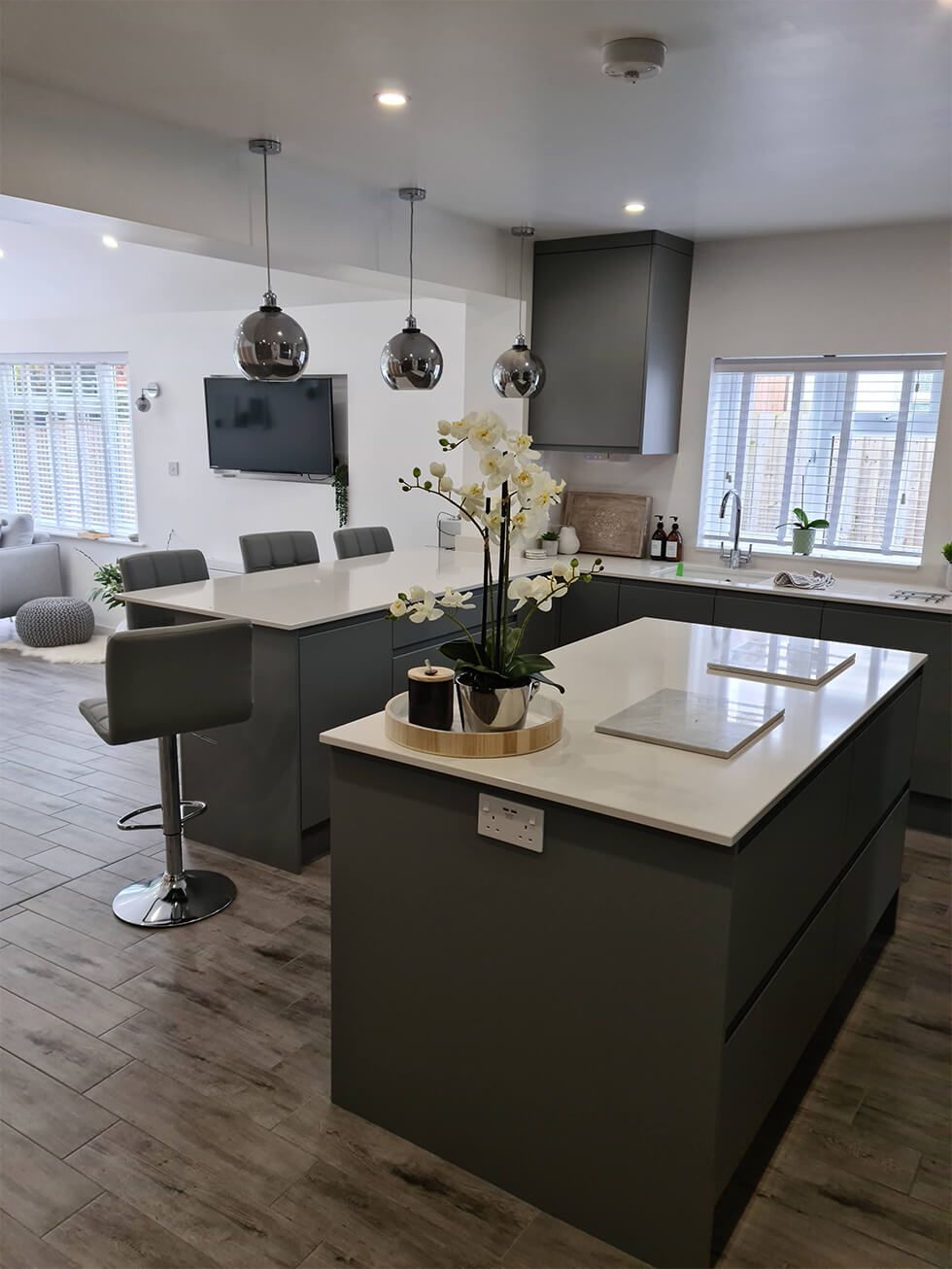 Contemporary open plan grey and white kitchen with granite tops