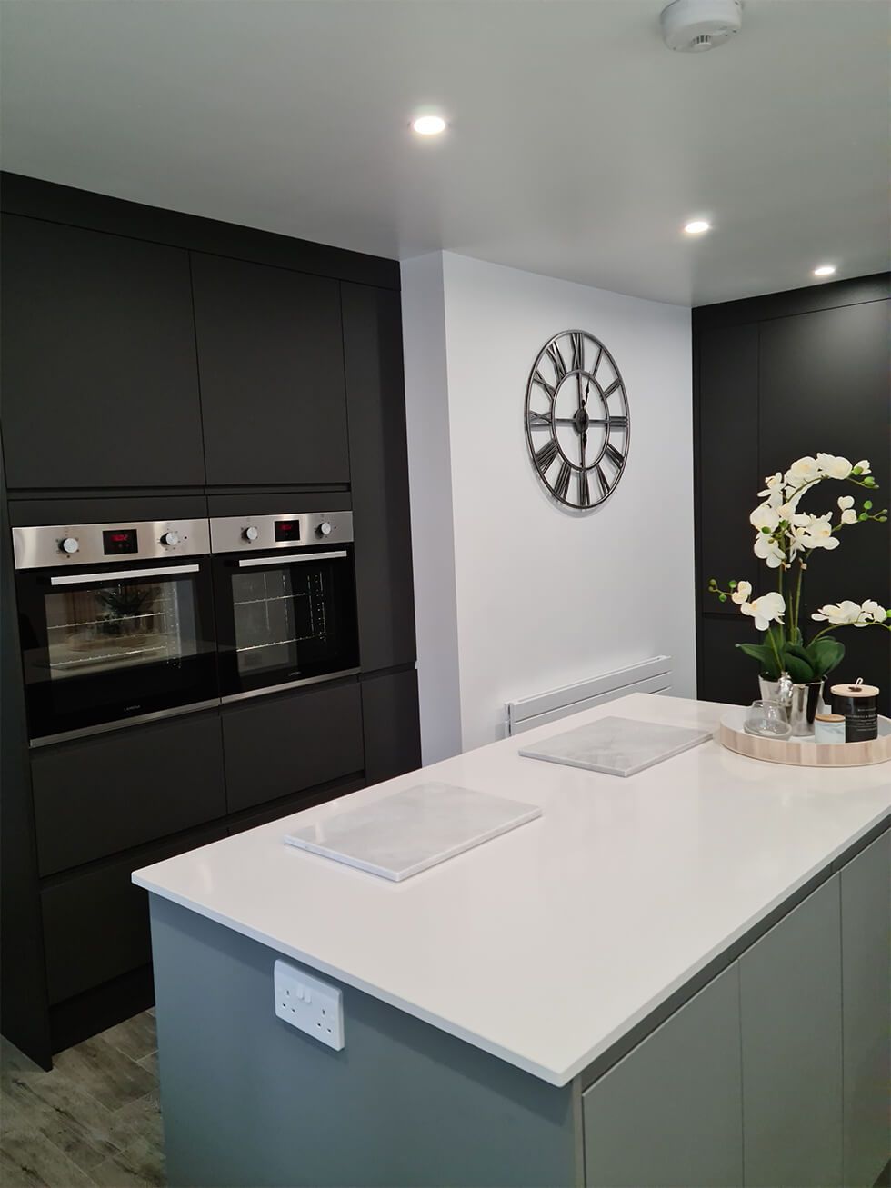 Stylish and organised charcoal floor to ceiling cupboards in a contemporary kitchen