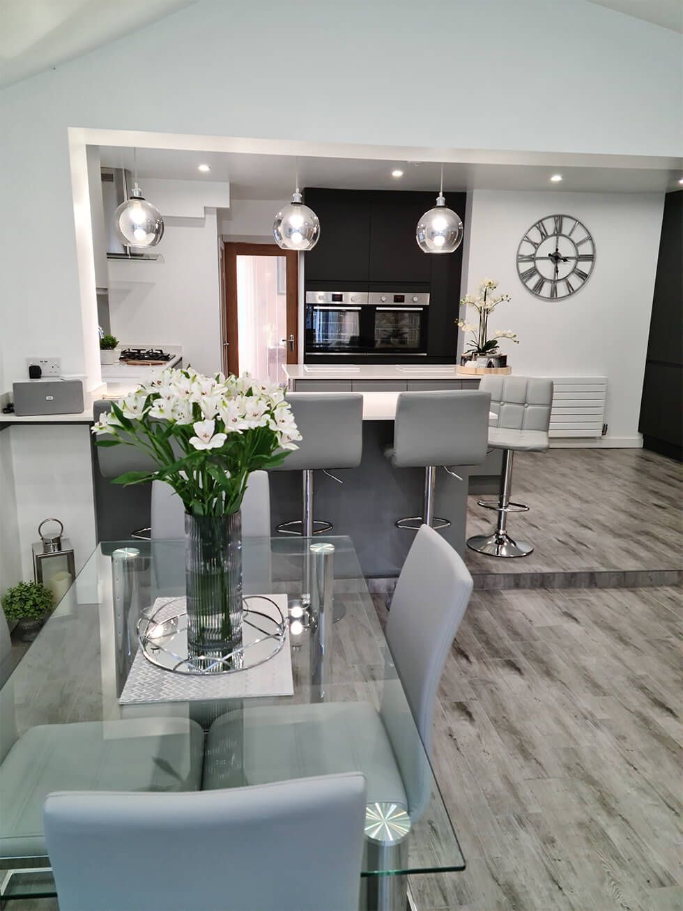 Contemporary open plan kitchen diner with greenery and flowers