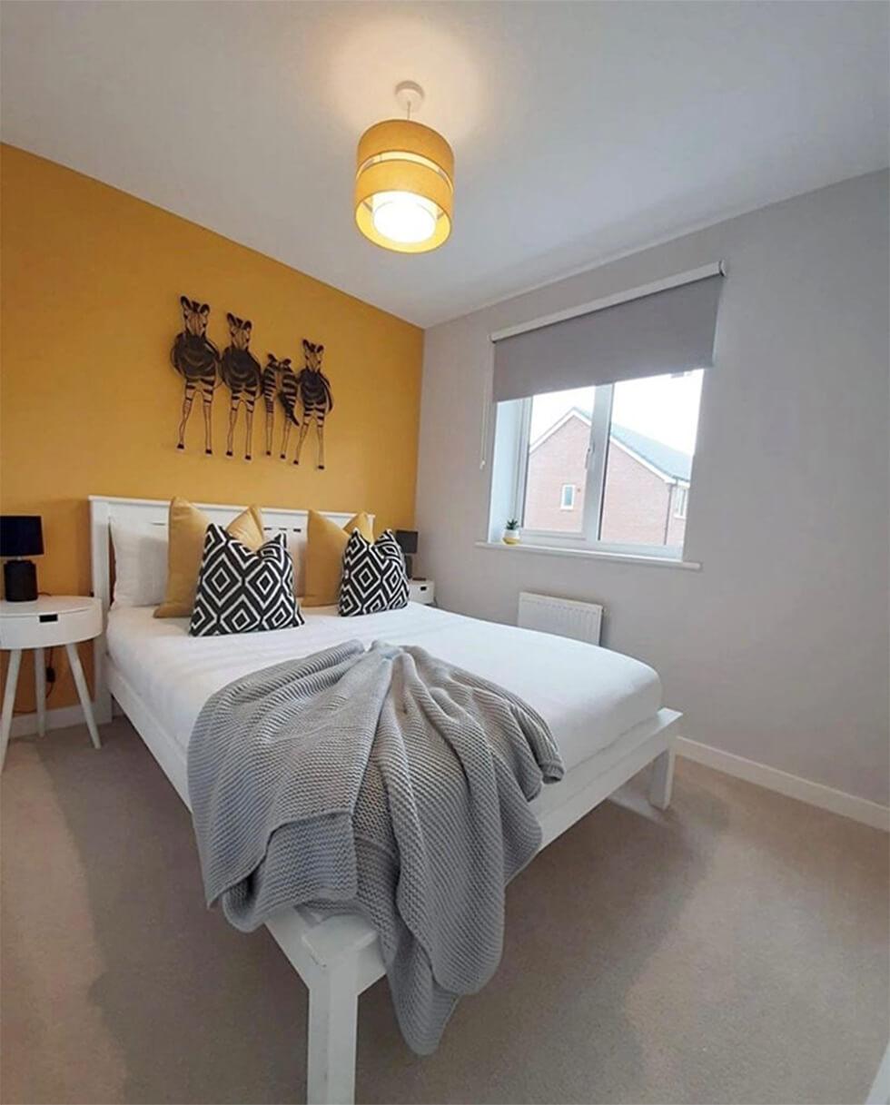 guest room with yellow walls and white bed