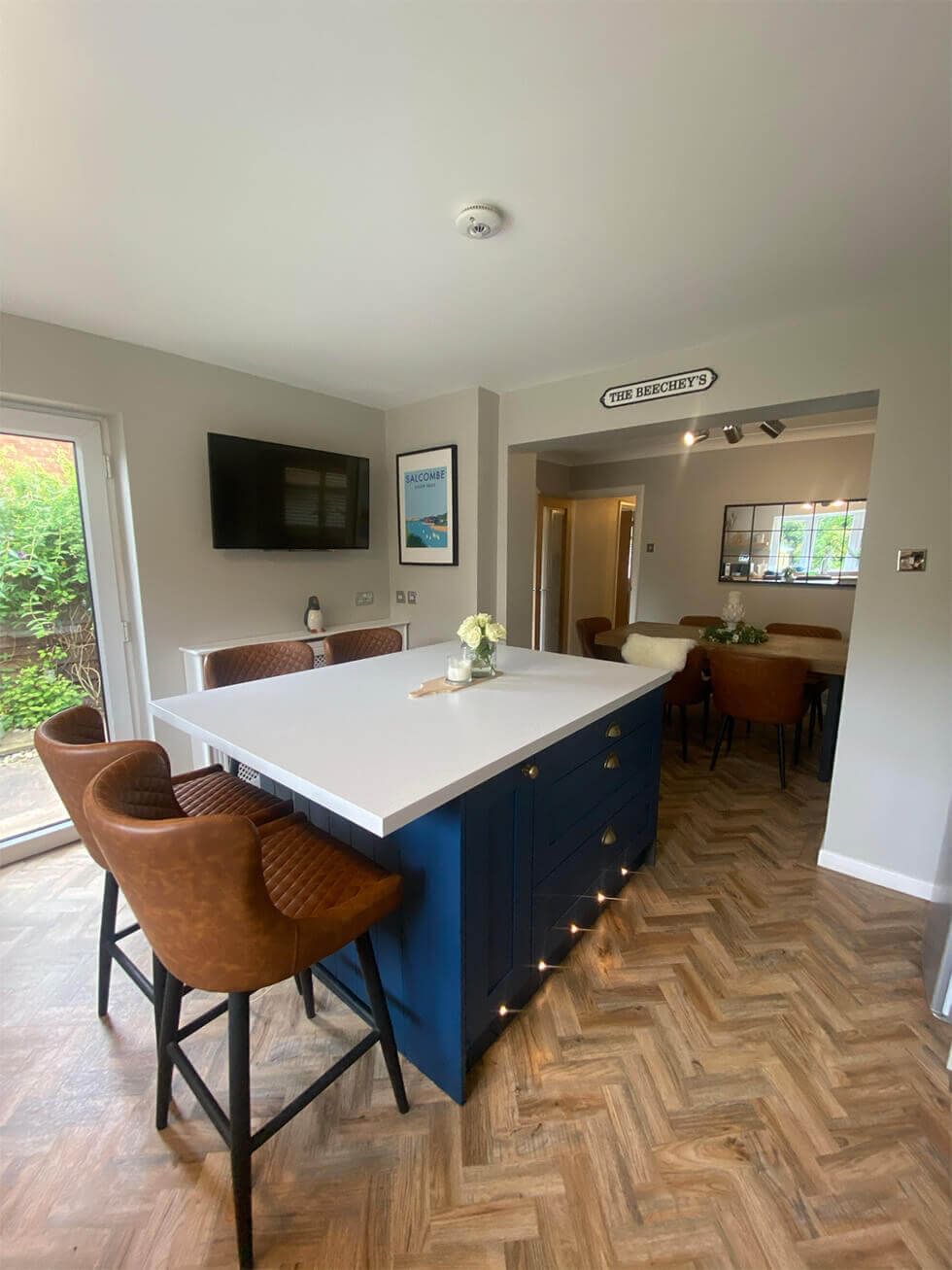 Dark blue kitchen island in a wooden kitchen-diner