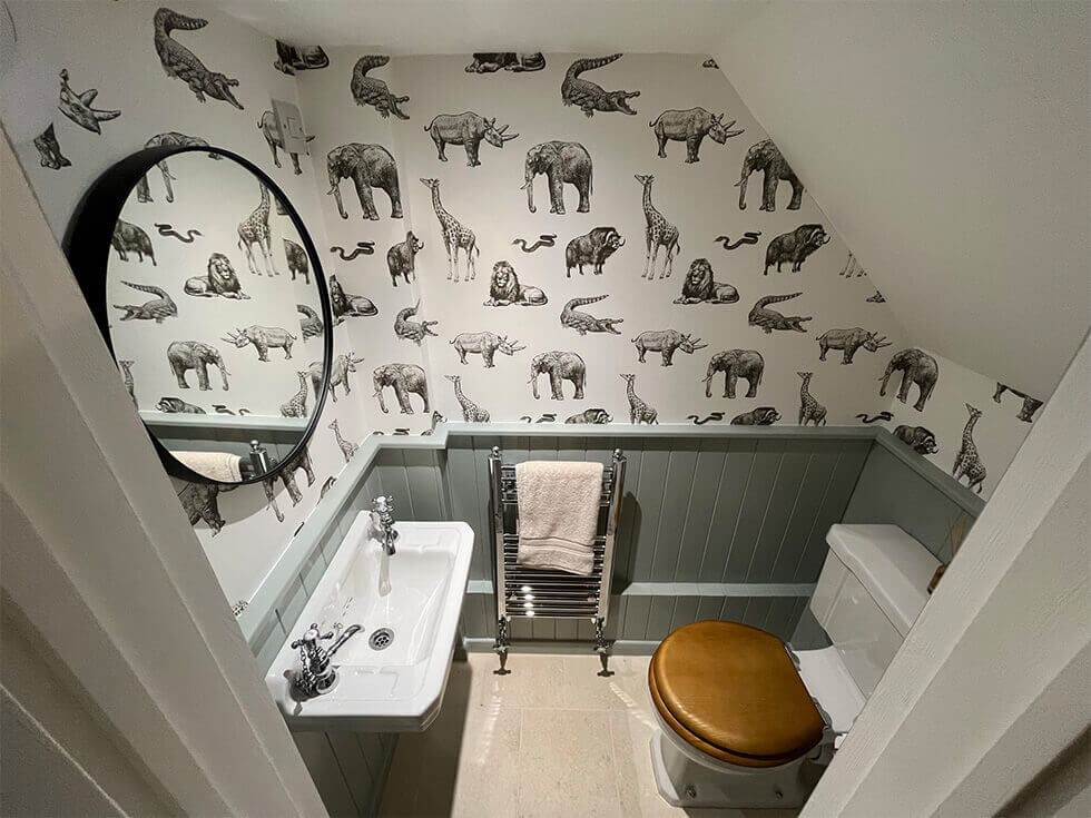 Guest bathroom with animal wallpaper and grey wall panelling