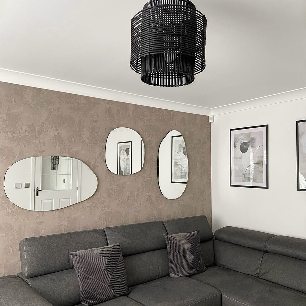 Living room with beige walls, grey sofa and pond-shaped mirrors