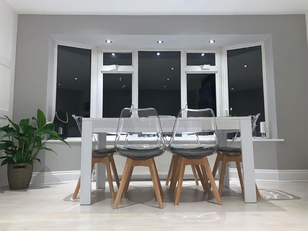 Wooden table and acrylic dining chairs in open plan dining area