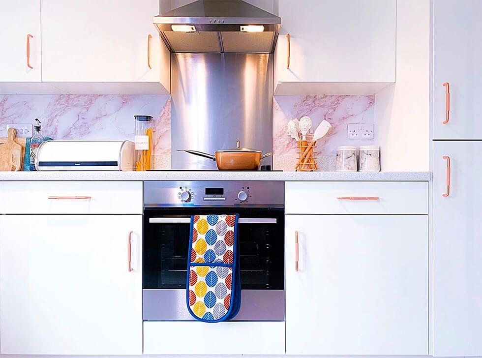 Modern white kitchen with a marble backsplash and steel appliances