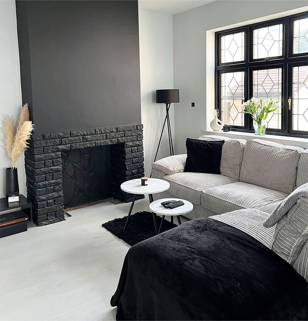 Black fireplace in monochrome living room and cord sofa