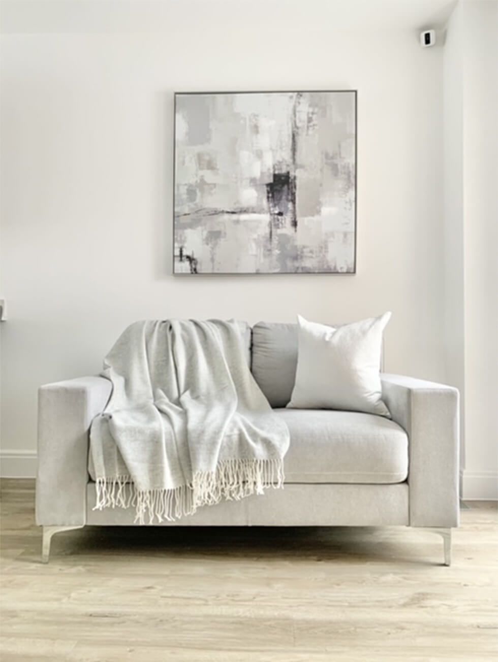 Modern light grey Baltimore sofa and abstract wall art above it