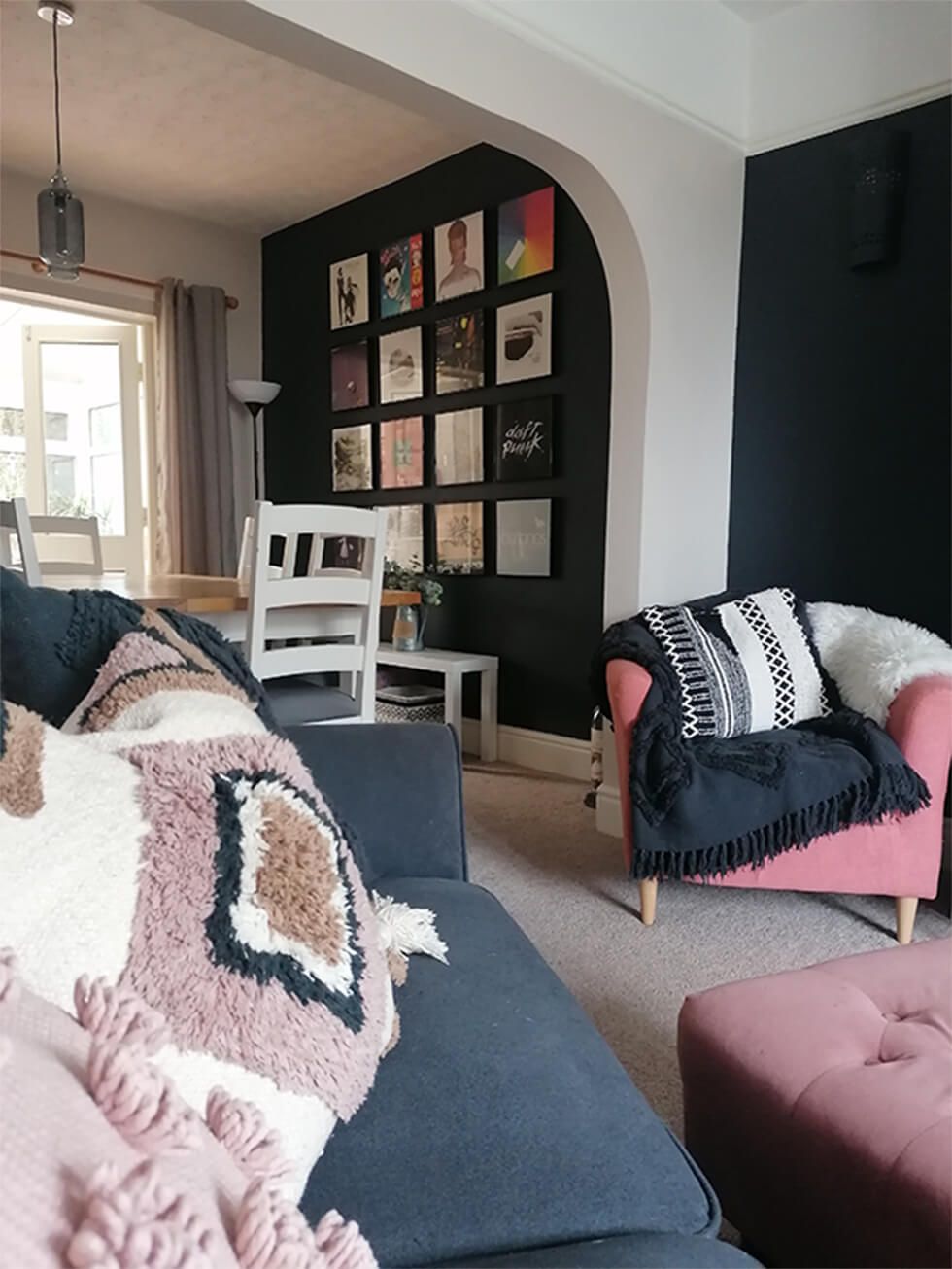 Grey sofa with textured cushions in a black and pink living room