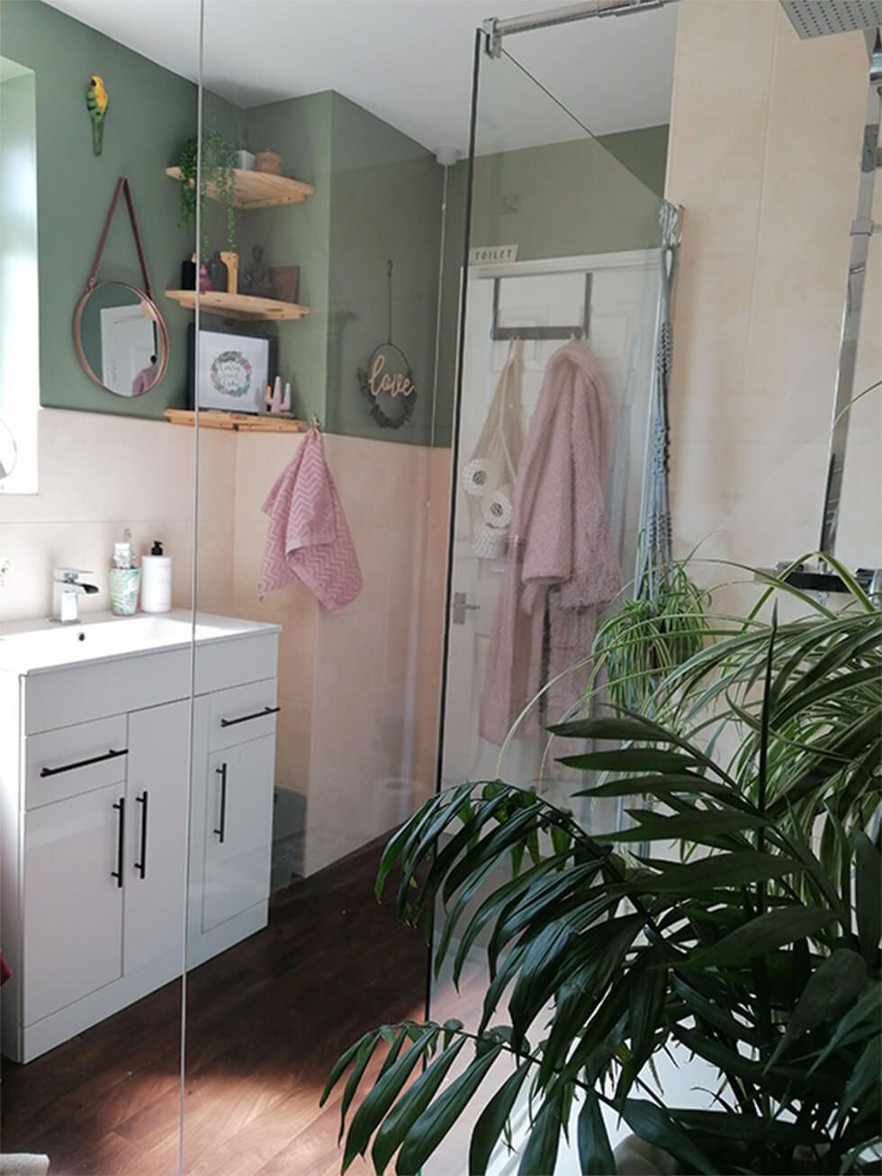 Tropical-inspired bathroom with green walls and indoor plants