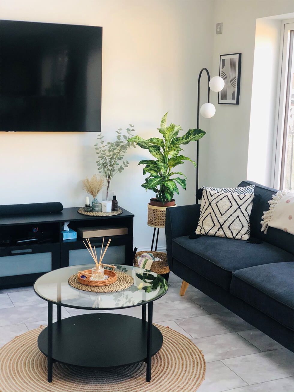 A boho living room featuring our Harlow sofa, a coffee table, plants and a jute rug