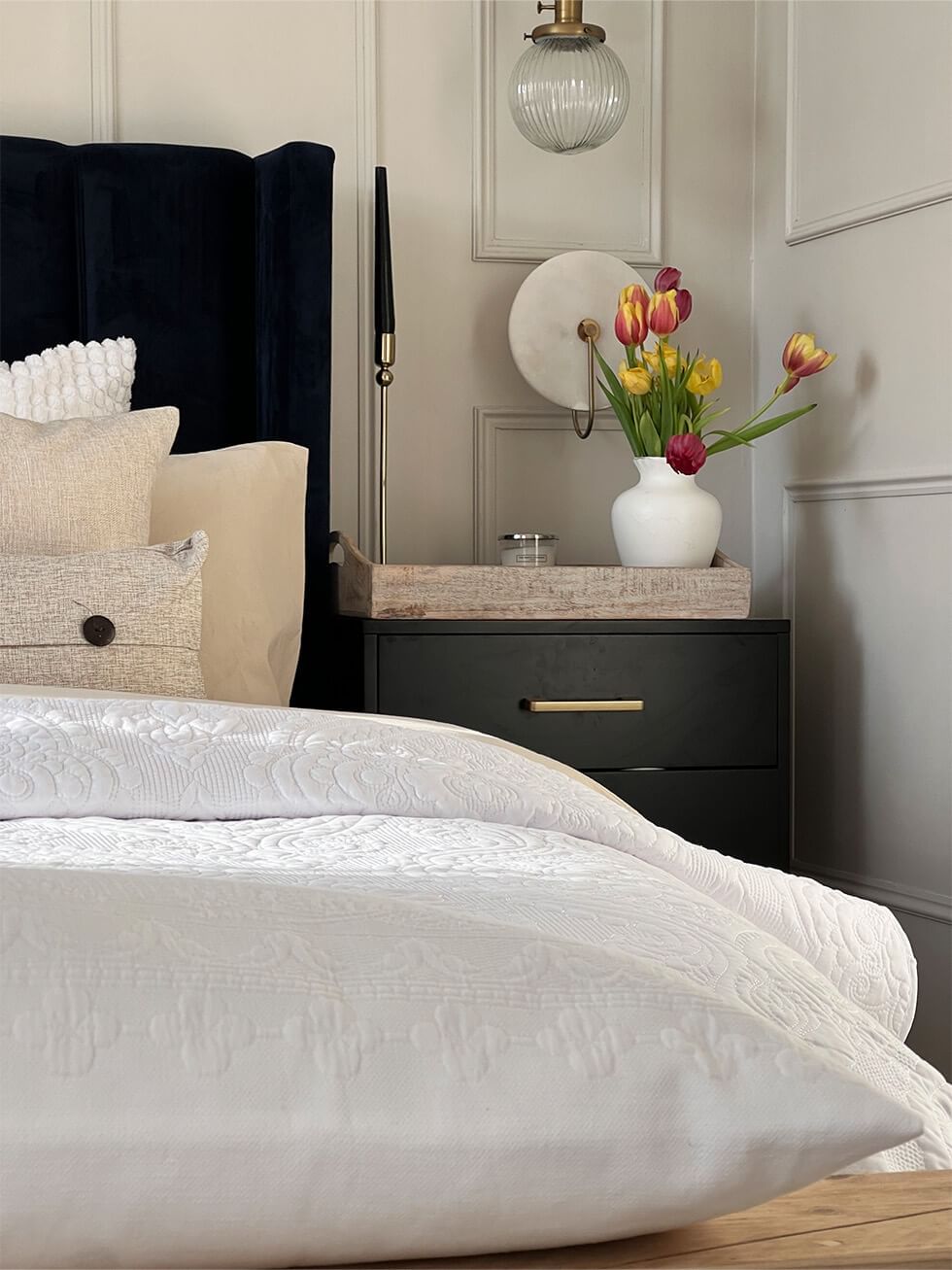 Bedroom with white bedding, hotel style pillows and boudoir cushions