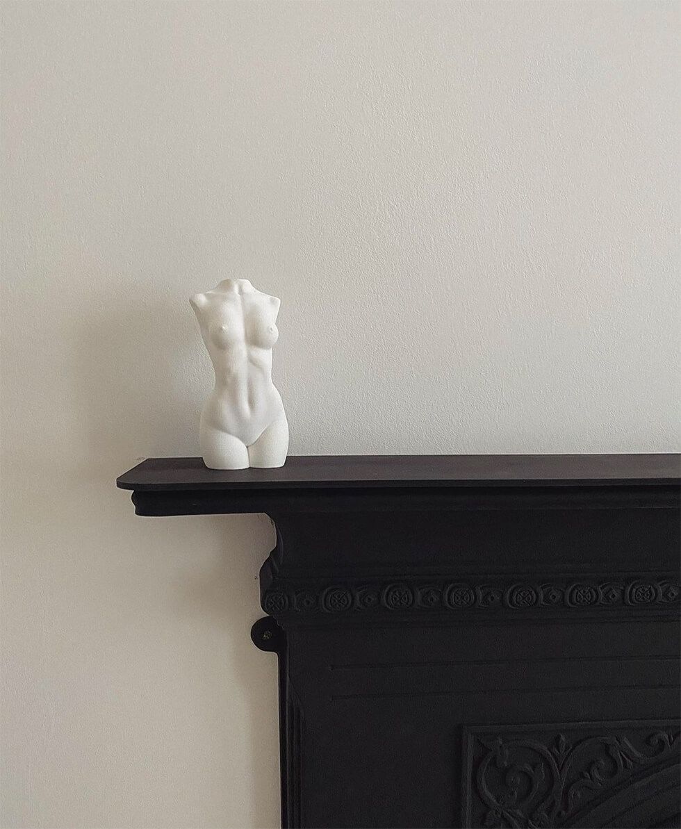 A nude vase on matt black fireplace