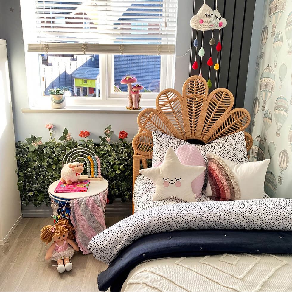 A rattan kids bed, soft toys and floral touches