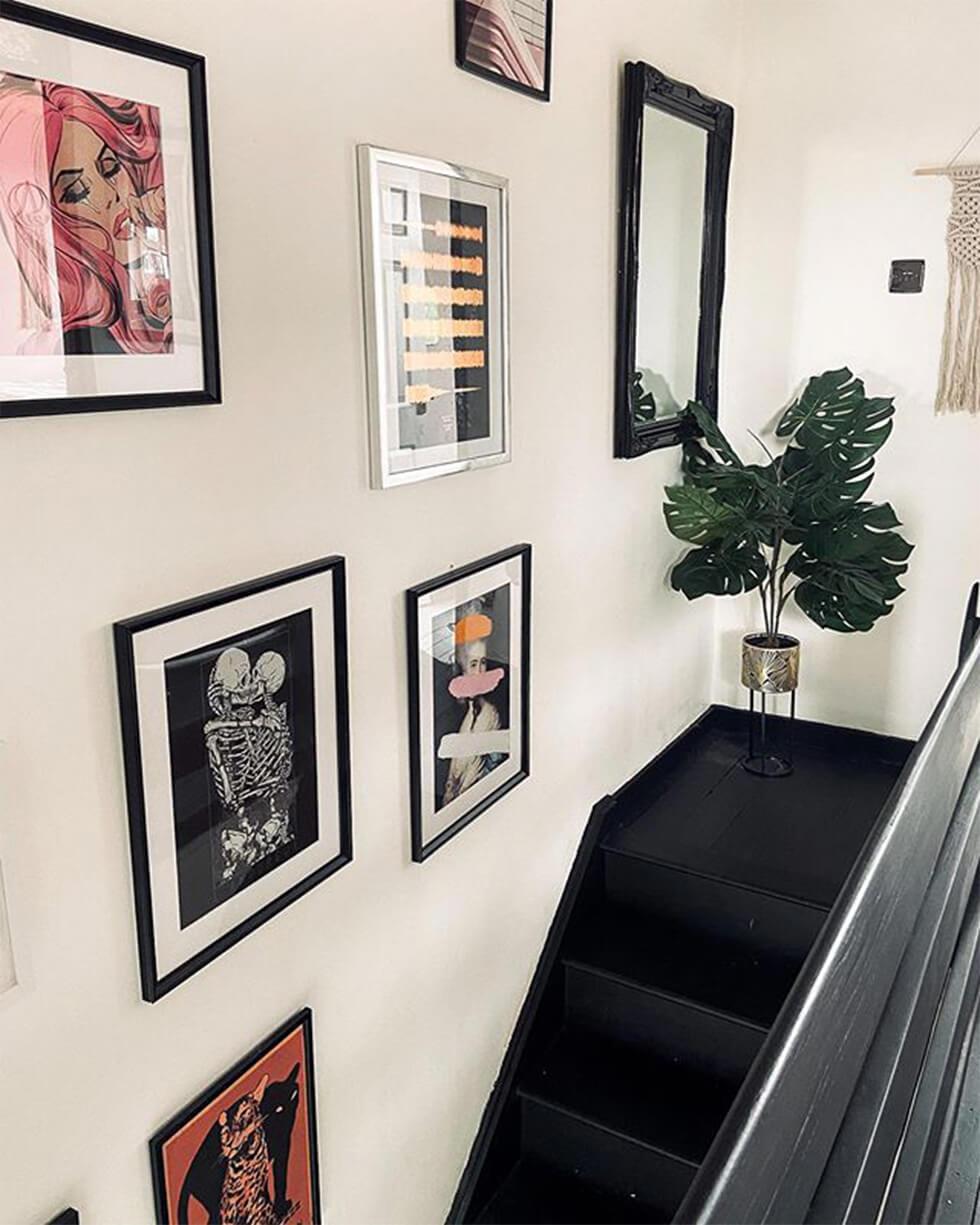 gallery wall landing by black wooden staircase