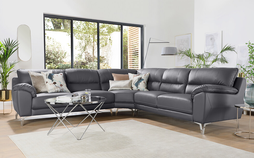 grey leather corner sofa with chrome detailing in a modern white living room