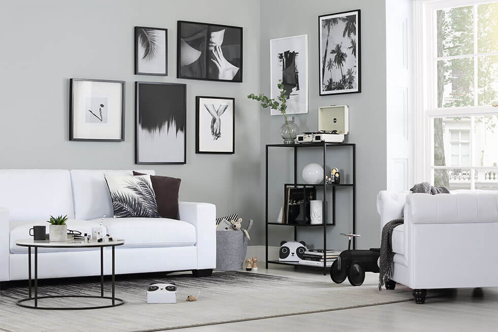 Modern white living room with white leather sofa set and black table and decor.