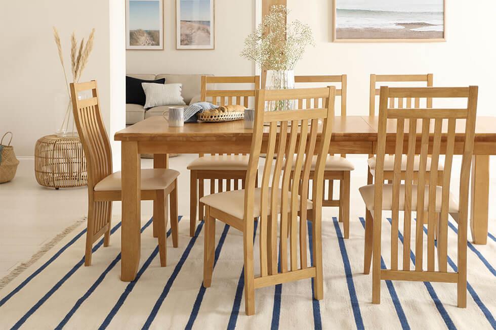 Nautical inspired dining room with oak wooden dining table and slatted back wooden dining chairs.