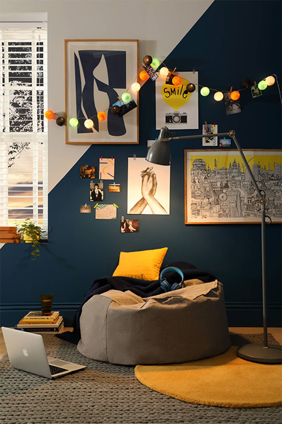 A relaxation corner in a teenager's room with a geometric wall, bean bag and string lights