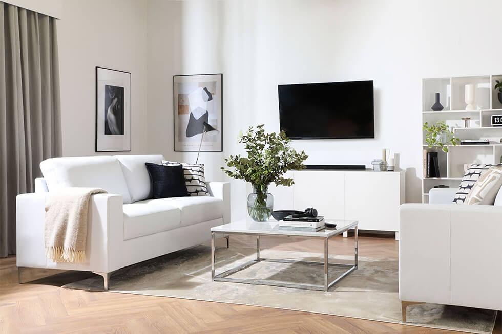 White leather sofas dressed with monochrome black and white cushions in a contemporary living room