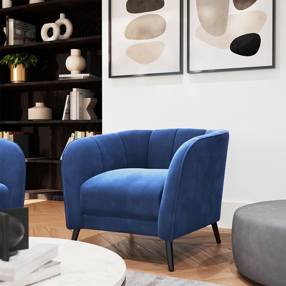 Monochrome reading corner with a blue velvet armchair