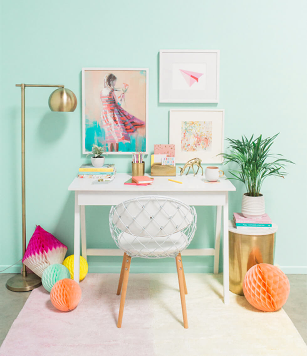 Home office with turquoise walls and brass accessories