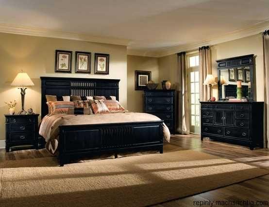 Large bedroom with a big black bed and warm lighting