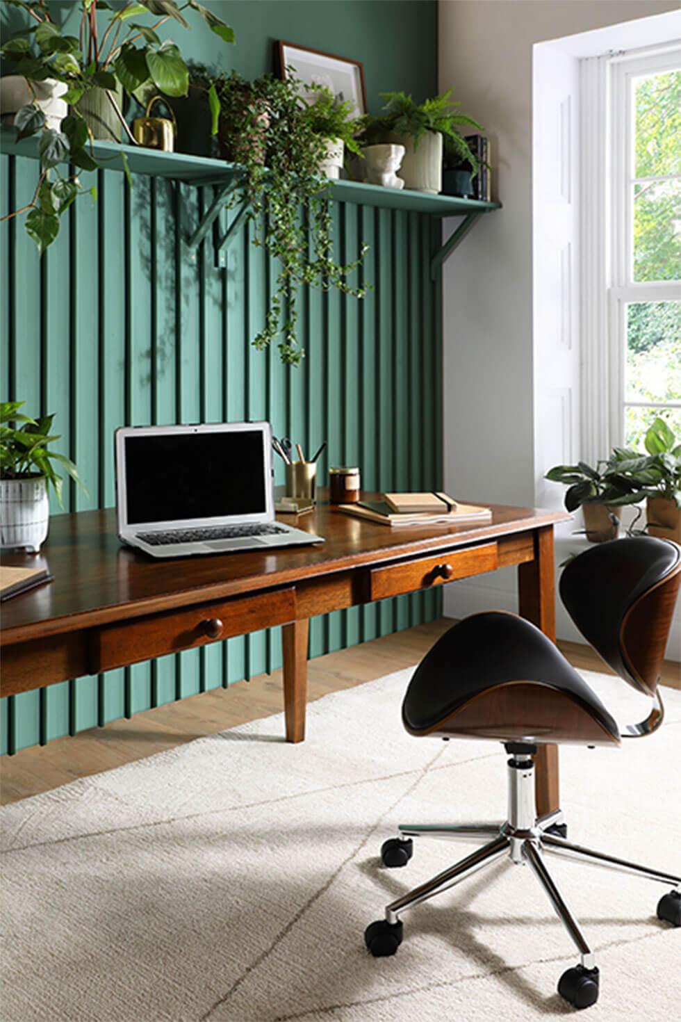 Dark wood dining table with storage and green wood panel walls