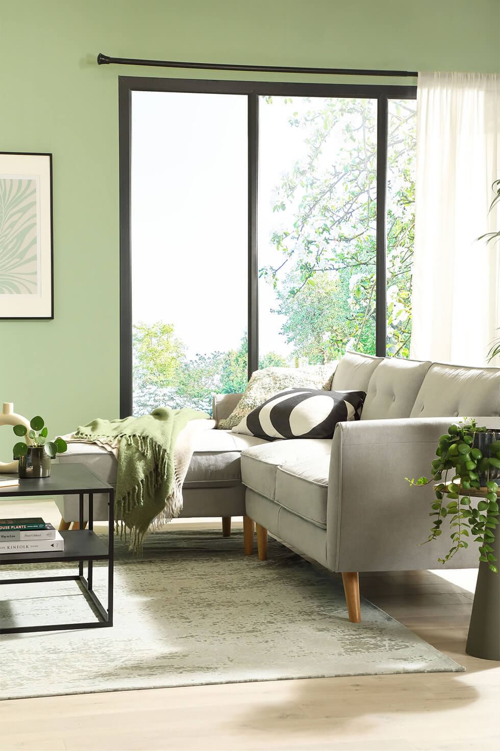 Green living room with grey sofa and natural light