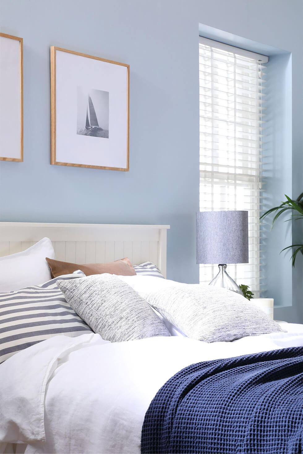 Blue bedroom with white wooden bed