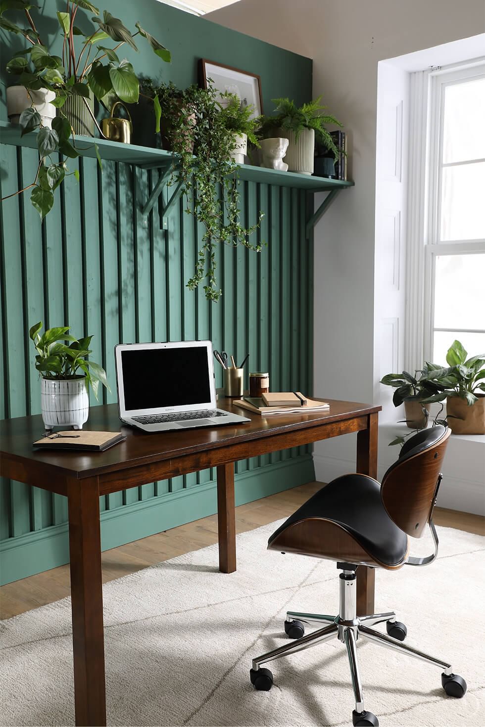Home office with green walls and wooden desk