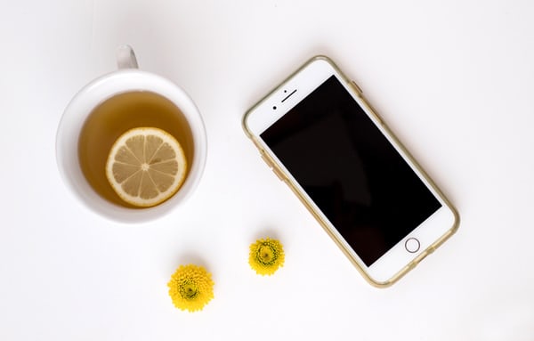 iPhone with lemon tea and yellow flowers