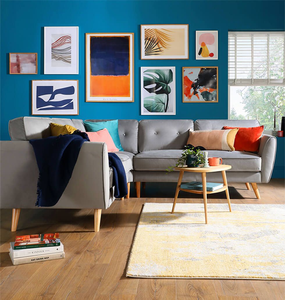 Modern velvet sofa in a living room with a colourful feature wall