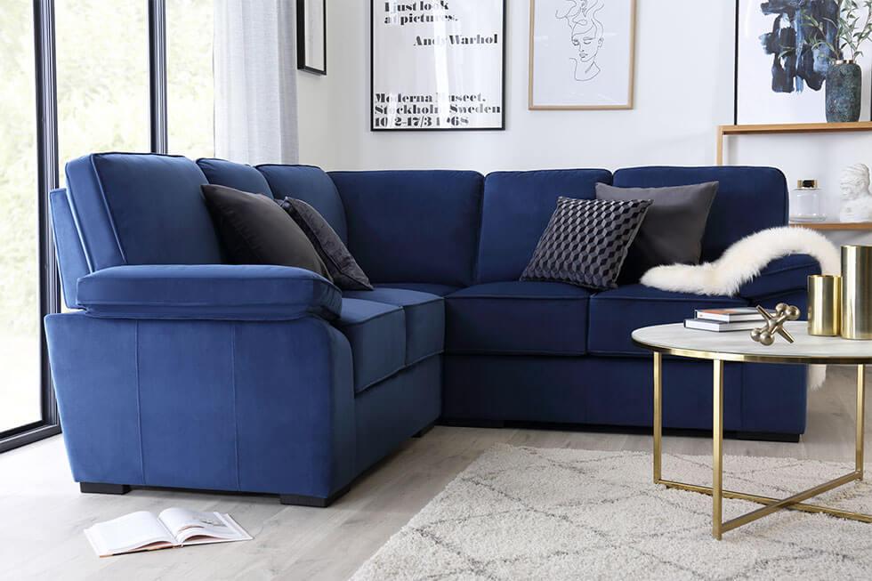 Classic blue velvet sofa in the living room with a minimalist brass coffee table