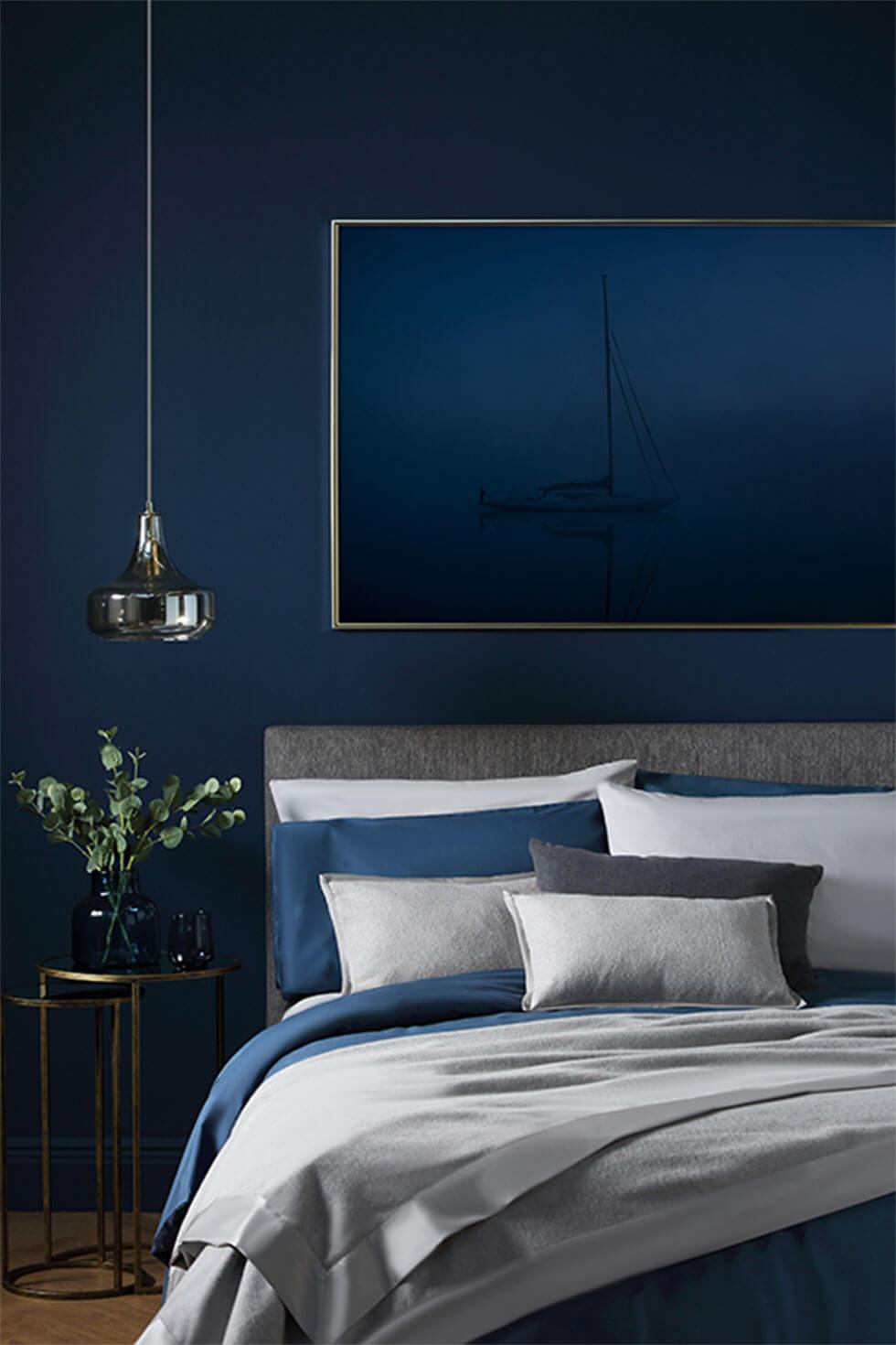 Classic blue bedroom with feature wall and cosy bedding