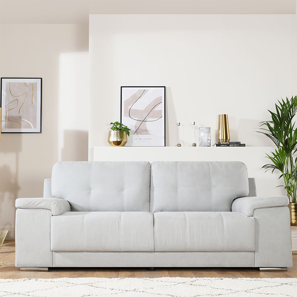 cosy neutral living room with light grey fabric sofa, rug and indoor plants