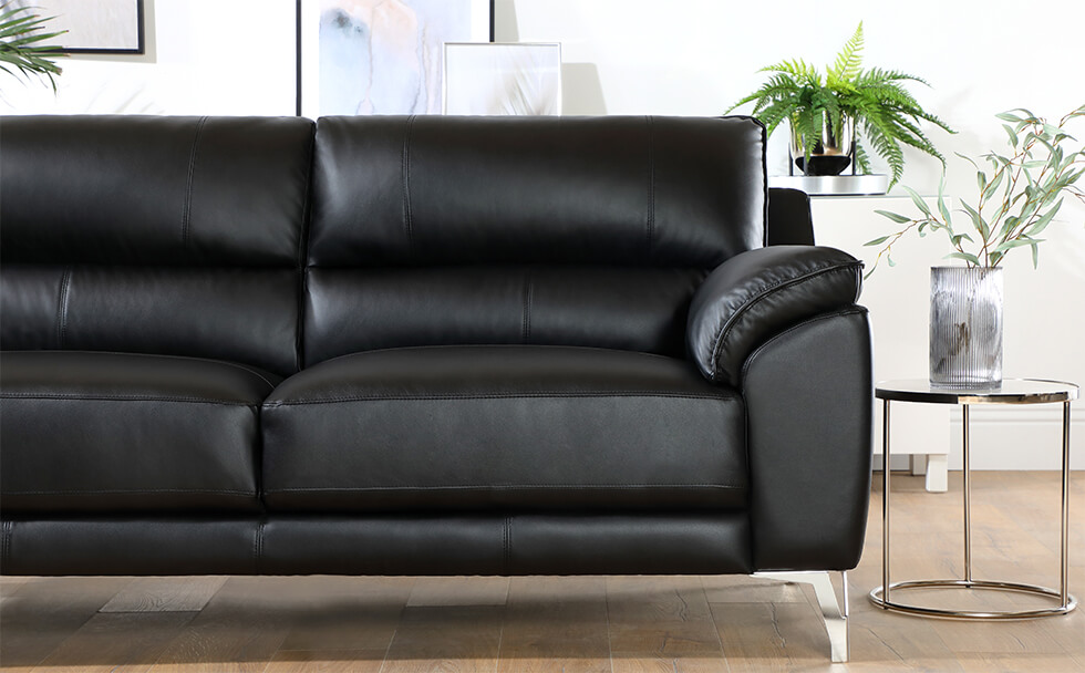 Black leather sofa with chrome legs in a modern living room