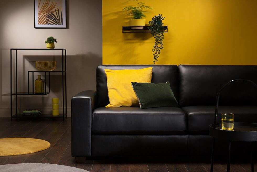 Black leather sofa in a grey and yellow living room