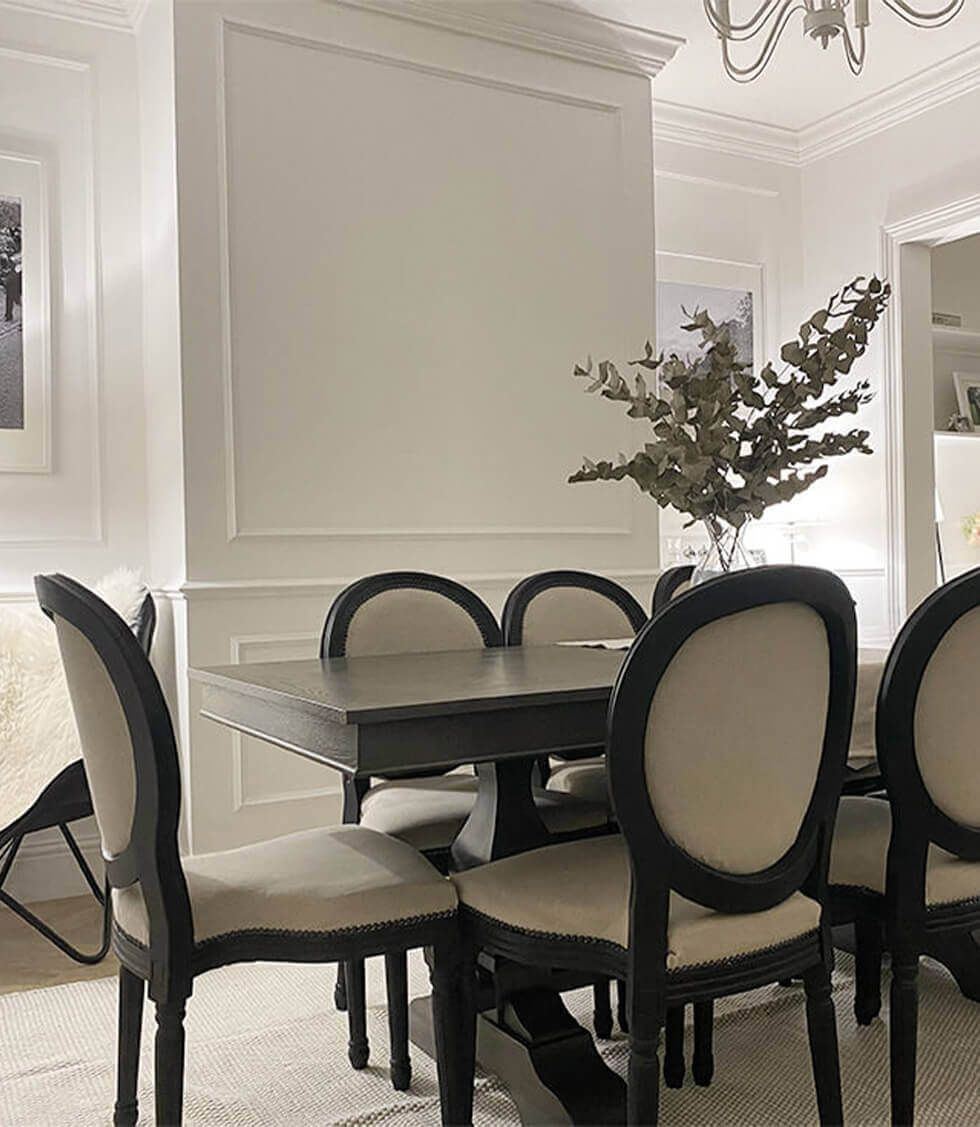 Timeless wooden dining table with white wall panelling backdrop