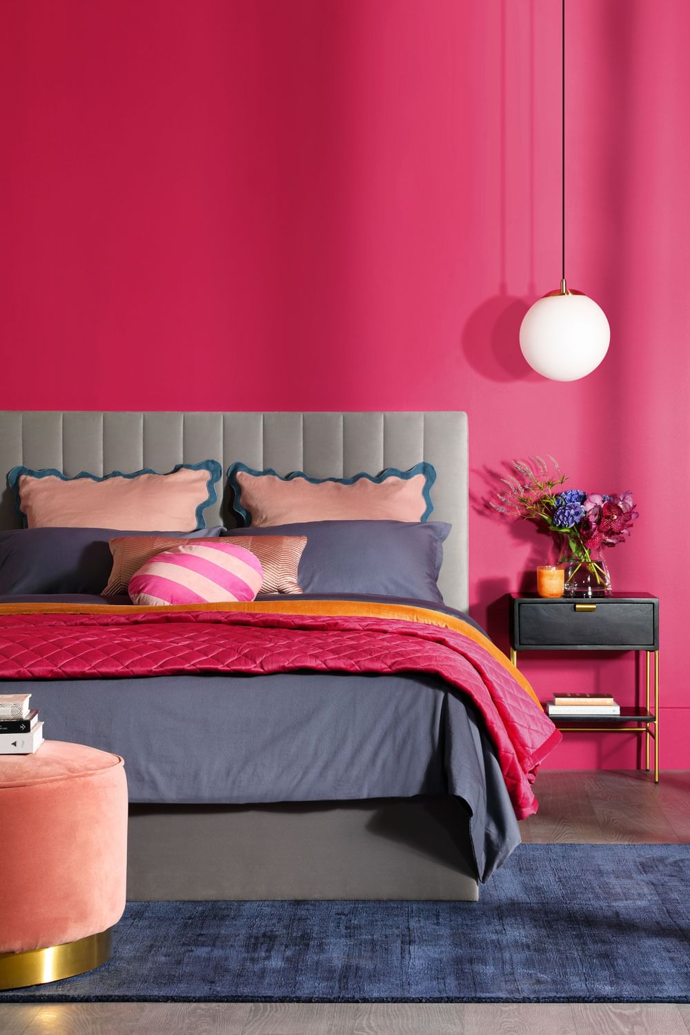 Bedroom with Viva Magenta feature wall, grey bed and pink accents